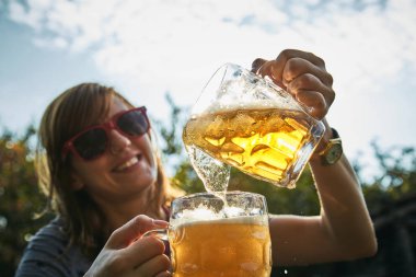 Sevimli kız iki bardak bira açık havada oyun.