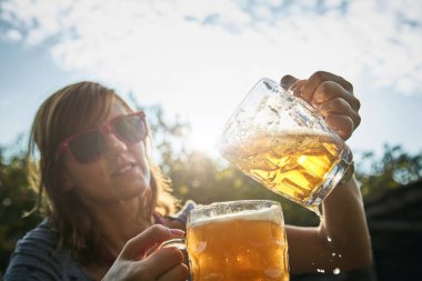 Sevimli kız iki bardak bira açık havada oyun.