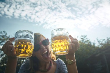 Sevimli kız iki bardak bira açık havada oyun.