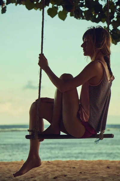 Mujer joven balanceándose en una playa tropical de arena . — Foto de Stock