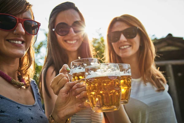 Grupo de mujeres jóvenes disfrutando y animando cerveza al aire libre . — Foto de Stock