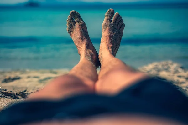 Człowiek leżący i cieszyć się przy tropikalnej, piaszczystej plaży. — Zdjęcie stockowe
