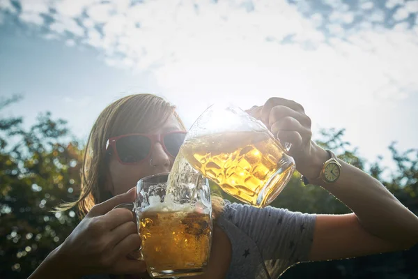 Linda chica jugando con dos vasos de cerveza al aire libre . — Foto de Stock