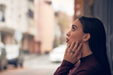 Sokakta poz veren üzgün genç kadın.