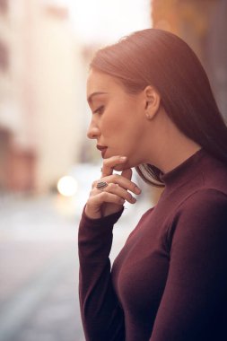 Sokakta poz veren üzgün genç kadın.