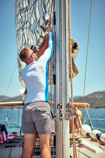 Marinaio imballaggio / disimballaggio ala vela principale sulla barca . — Foto Stock
