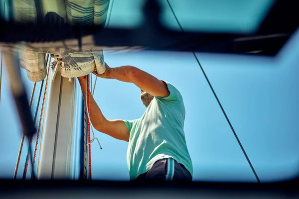 Sailor csomagolás / kicsomagolás fővitorla szárny a hajón. — Stock Fotó