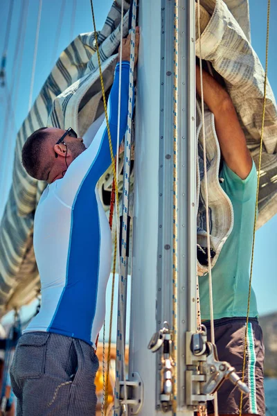 Marinero embalaje / desembalaje vela principal ala en el barco . — Foto de Stock