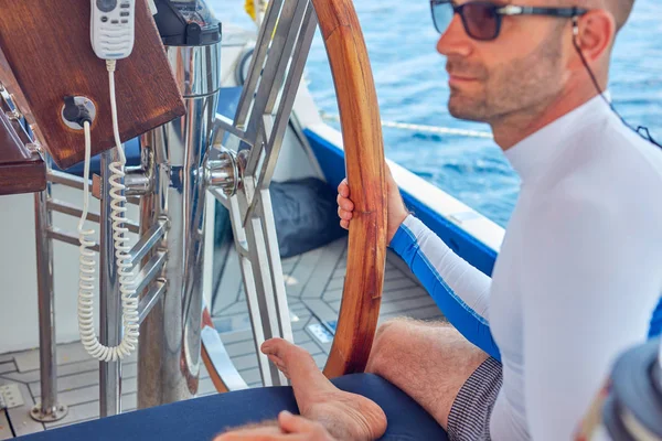 Sailor using wheel to steer rudder on a sailing boat. — Stock Photo, Image