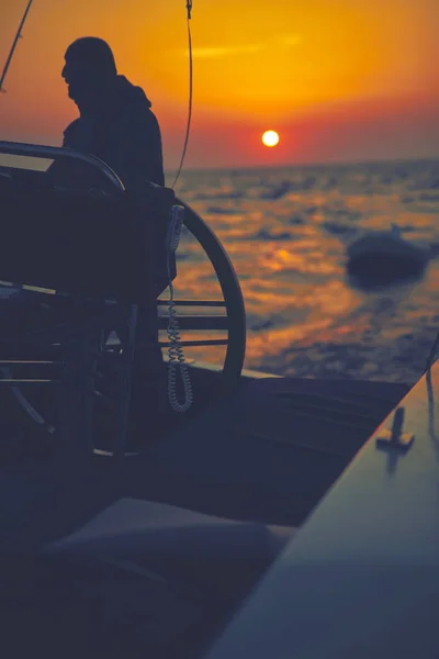 Zeiler met behulp van wiel te sturen roer op een zeilboot. — Stockfoto
