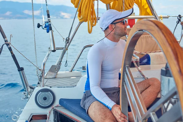 Sailor using wheel to steer rudder on a sailing boat. — Stock Photo, Image