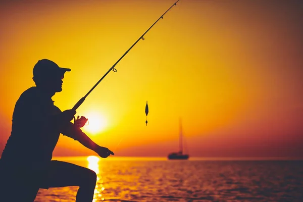 Silhouette eines Fischers, der bei Sonnenuntergang auf dem offenen Meer fischt — Stockfoto