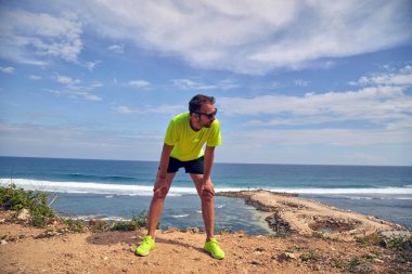 Okyanus yakınında tropikal egzotik uçurumun üzerinde uzanan Sportsman.