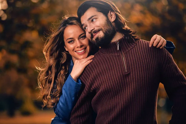 Pareja en la temporada de otoño colorido parque disfrutando al aire libre . — Foto de Stock