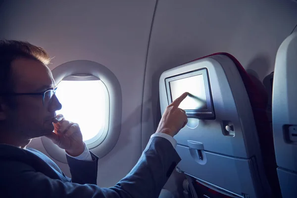 男子在现代飞机座位上使用触摸屏. — 图库照片