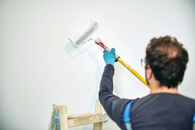 Ev içinde işçi boyama duvarları-yenileme düzeltmeleri.