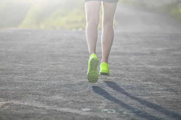 L'uomo fa jogging in discesa / salita in una strada di montagna di periferia . — Foto Stock