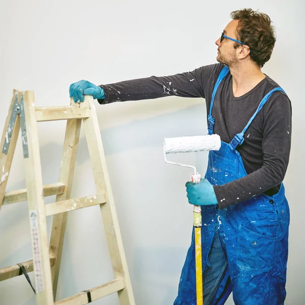 Munkás festés falak belsejében a ház-felújítás javítások. — Stock Fotó