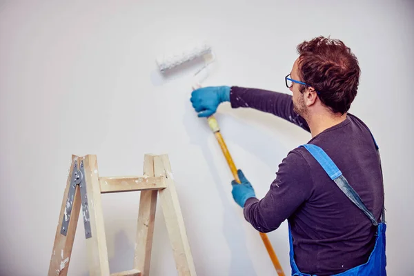 Paredes de pintura do trabalhador dentro da casa - consertos de renovação . — Fotografia de Stock