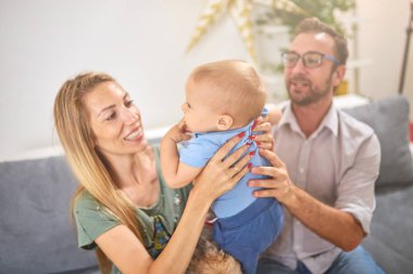 Ebeveynler evde bir bebek ile oynuyor.