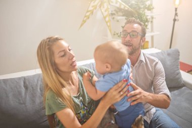 Ebeveynler evde bir bebek ile oynuyor.