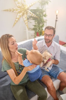 Ebeveynler evde bir bebek ile oynuyor.
