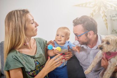 Ebeveynler evde bir bebek ile oynuyor.