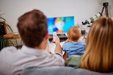 Genç ebeveynler izliyor TV ile bebek oğlan.
