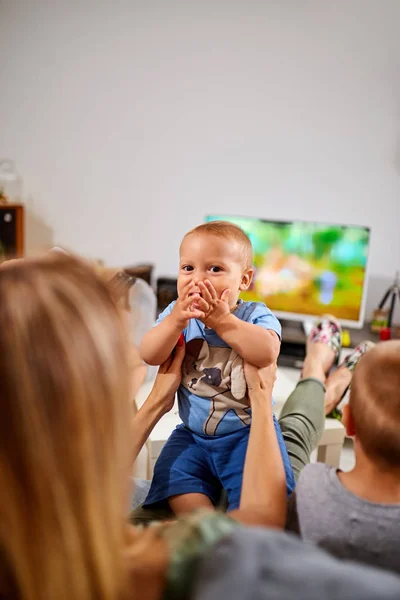Młodzi rodzice oglądając telewizję z chłopcami. — Zdjęcie stockowe