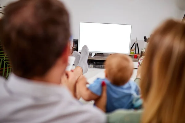 Młodzi rodzice oglądając telewizję z chłopcem. — Zdjęcie stockowe