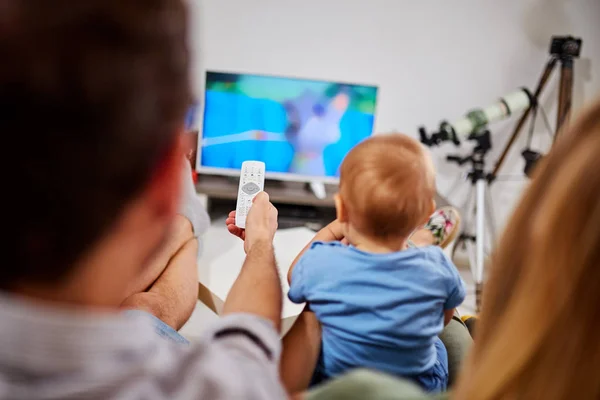 Młodzi rodzice oglądając telewizję z chłopcem. — Zdjęcie stockowe