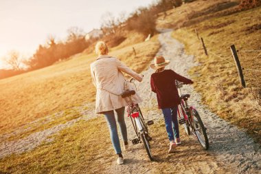 Kırsal kesimde bisikletli anne ve kızı.