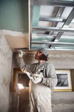 İnşaat işçisi evin içine alçıtaşı duvarları yapıştırıyor..