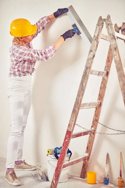 Working woman plastering / painting walls inside the house. — Stock Photo, Image