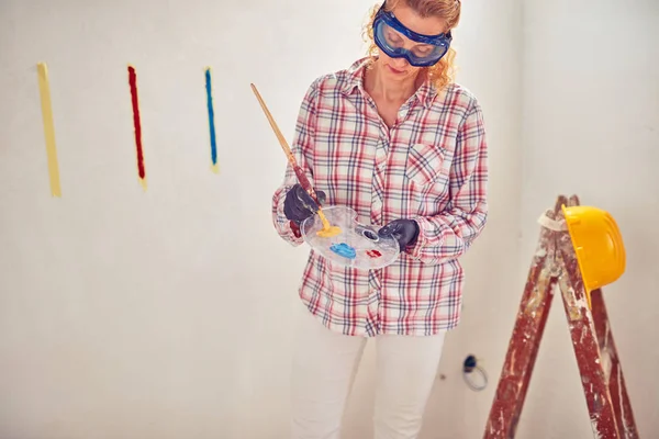 Εργασία γυναίκα πλεκτής/ζωγραφική τοίχους μέσα στο σπίτι. — Φωτογραφία Αρχείου