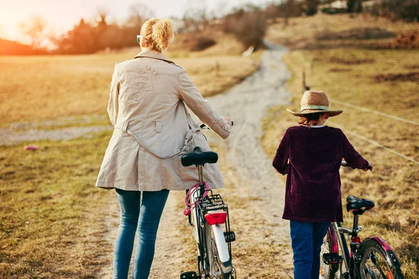 Mãe e filha com bicicletas no campo . — Fotografia de Stock
