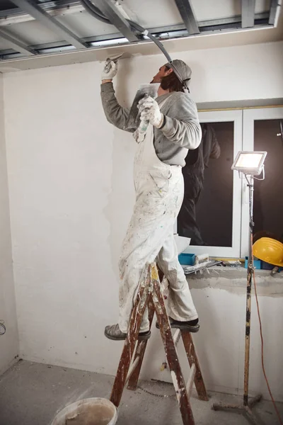 Trabajador de la construcción enyesado paredes de yeso dentro de la casa . — Foto de Stock