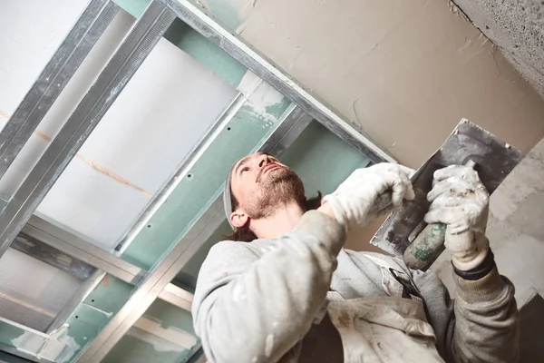 Trabalhador da construção civil reboco paredes de gesso dentro da casa . — Fotografia de Stock