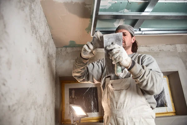 Construction worker plastering gypsum walls inside the house. — Stock Photo, Image