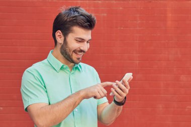 Sokakta akıllı telefon kullanan yakışıklı bir adam..