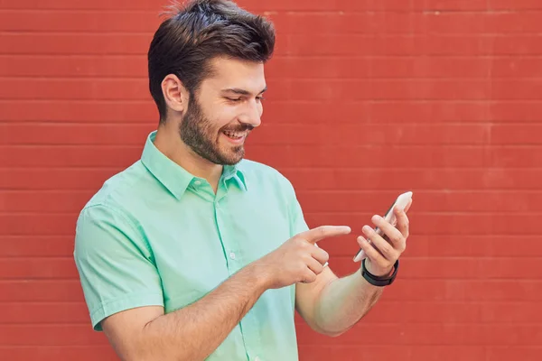 Hombre guapo usando smartphone en la calle . — Foto de Stock