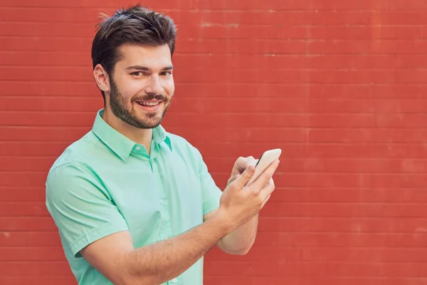 Hombre guapo usando smartphone en la calle . —  Fotos de Stock