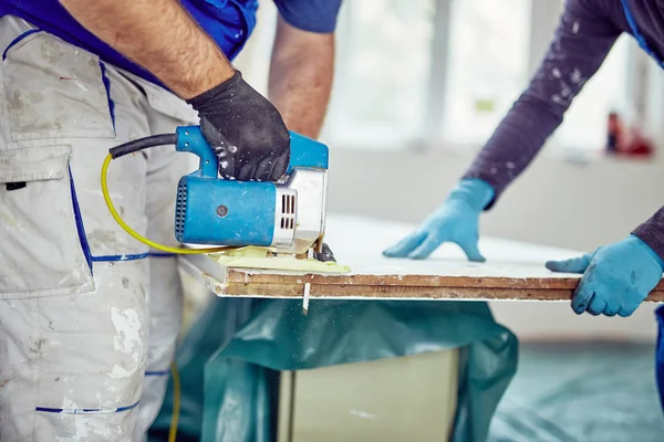 Two handymen working together on a house renovation.