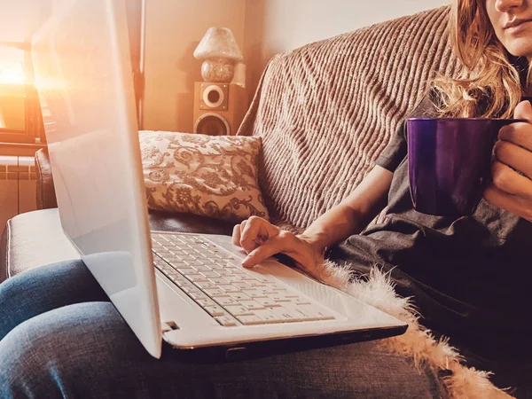Mulher usando laptop em um sofá em casa . — Fotografia de Stock