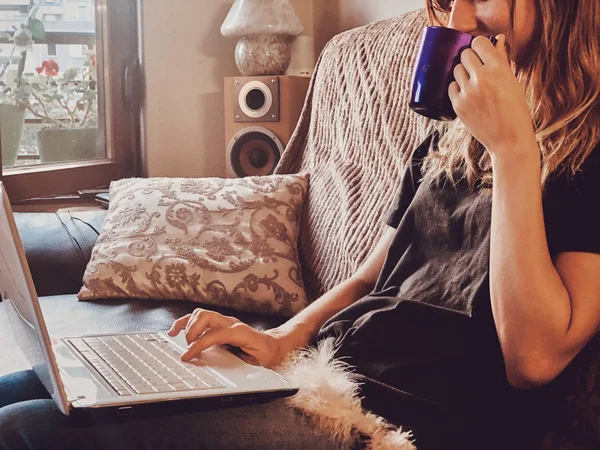 Жінка використовує ноутбук на домашньому дивані . — стокове фото