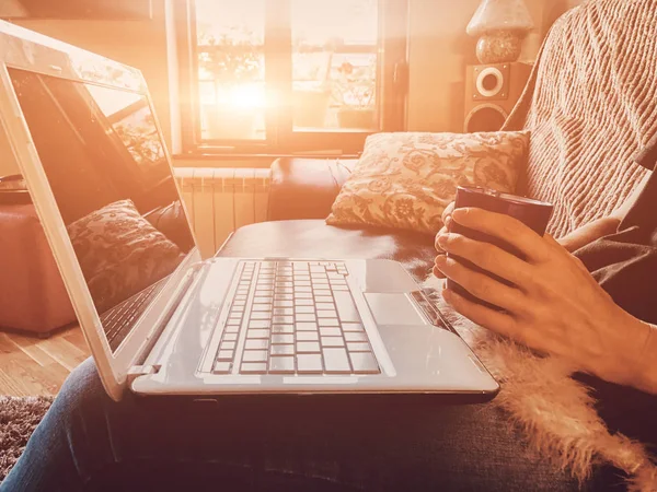 Mulher usando laptop em um sofá em casa . — Fotografia de Stock