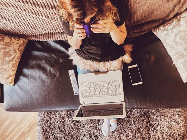 Жінка використовує ноутбук на домашньому дивані . — стокове фото