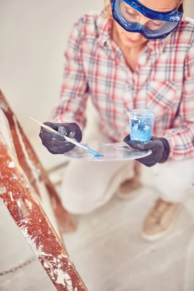 Working woman plastering / painting walls inside the house. — Stock Photo, Image