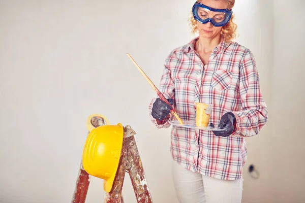 Working woman plastering / painting walls inside the house. — Stock Photo, Image