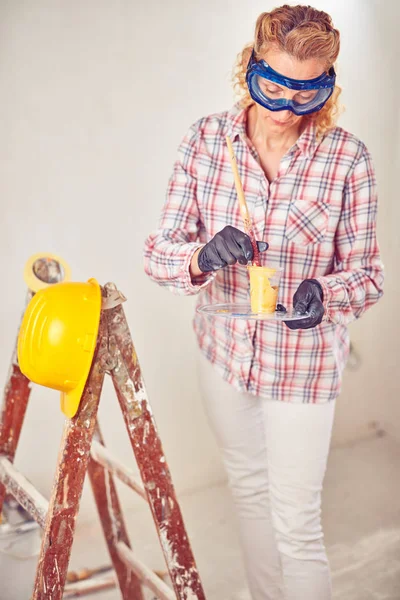 Working woman plastering / painting walls inside the house. — Stock Photo, Image